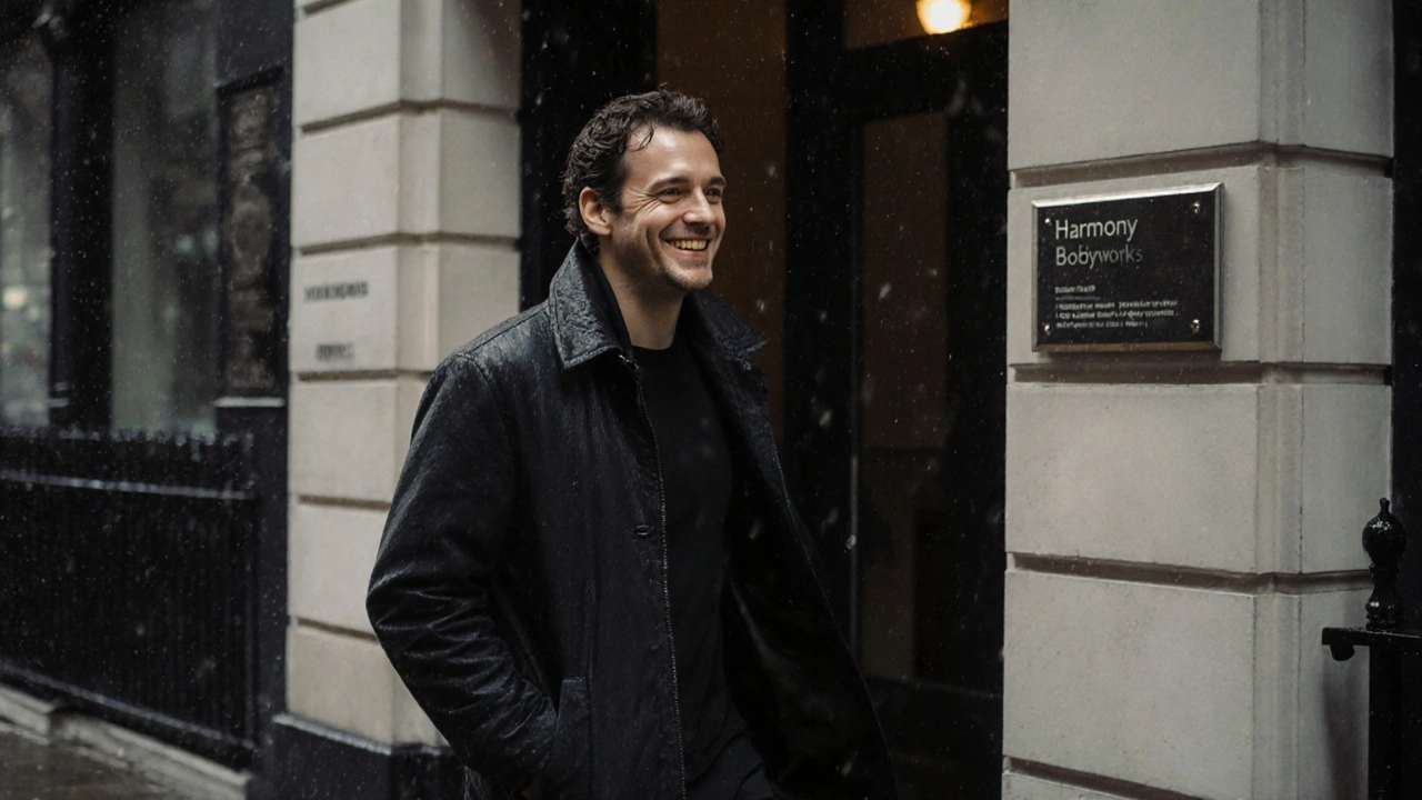 A man walks in the rain after a massage, smiling, phone-free, shoulders relaxed, city blurred behind him.
