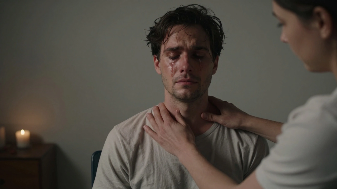 Man in a T-shirt crying silently during an Indian head massage, warmth radiating from his shoulders.